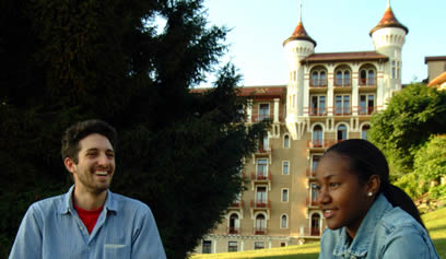 Two people talk on lawn at Caux