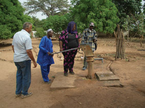 Judy Browne (centre) at the water pump in a village in Gambia