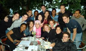 2004 Caux Scholars and friends gather to celebrate Mona Ayyad's (Palestine, center wearing head scarf) birthday.  Front row (l-r):  Ifeoma Malo (Nigeria), Hala Fleihan (Lebanon), Mona Ayyad (Palestine), Genevieve LeBaron (Canada), Sara Kushnick (USA), Alicia Miller (USA), Zeke Reich (USA).  Back row:  Danielle Ressler (USA) Pablo Alvarez Tostado (Mexico), unknown, Michelle Grainger (Guyana), Zamira Yusufjanova (Tajikistan), Chris deBree (USA), Christie Shrestha (Nepal), Ibtihal Mergani (Sudan), Juan Ordaz Ruiz (Mexico), Joseph Walla (USA), Yama Torabi (Afghanistan).
