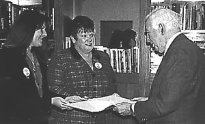 Former Governor-General of Australia Sir Zelman Cowen presents the Sorry Book he has just signed to Melissa Brickell (le